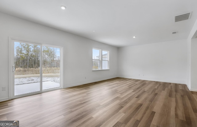 empty room with recessed lighting, visible vents, baseboards, and wood finished floors