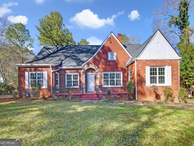 view of front of house featuring crawl space, brick siding, a chimney, and a front lawn