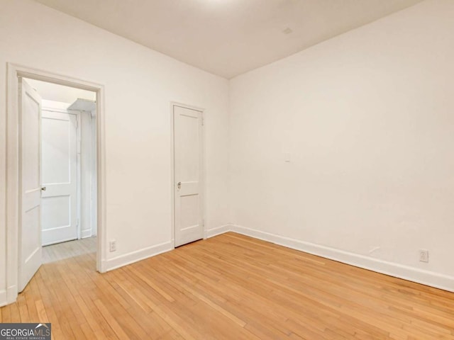 spare room with light wood-style flooring and baseboards