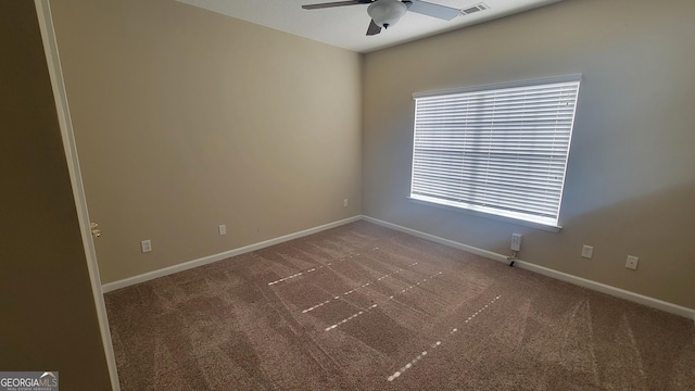 carpeted spare room featuring visible vents, ceiling fan, and baseboards