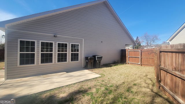 back of house with a patio, a lawn, and fence