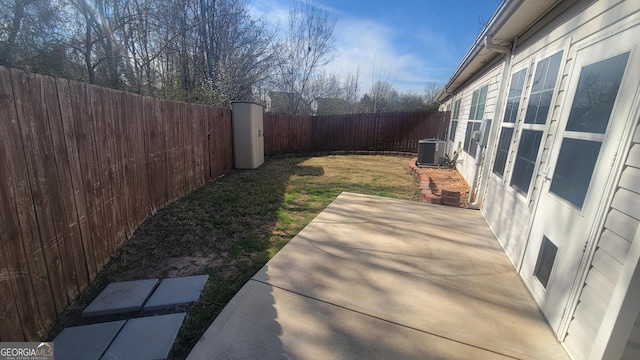 view of yard with a patio area, a fenced backyard, and central air condition unit