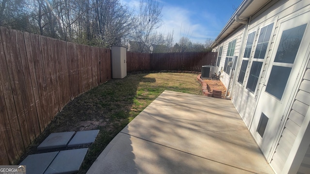 view of yard featuring cooling unit, a fenced backyard, and a patio