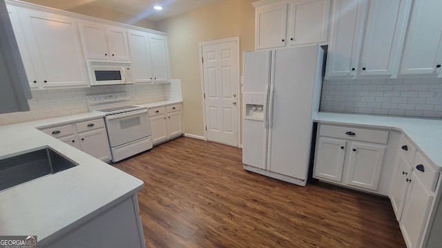 kitchen featuring white cabinets, white appliances, dark wood finished floors, and decorative backsplash