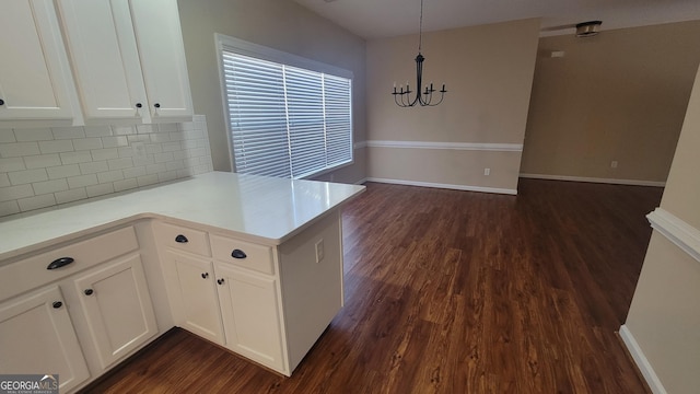 kitchen with dark wood-style flooring, tasteful backsplash, light countertops, white cabinets, and a peninsula