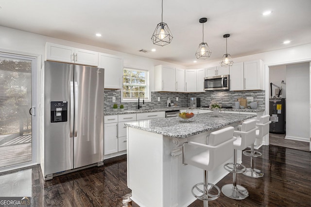 kitchen with visible vents, dark wood finished floors, appliances with stainless steel finishes, white cabinetry, and a sink