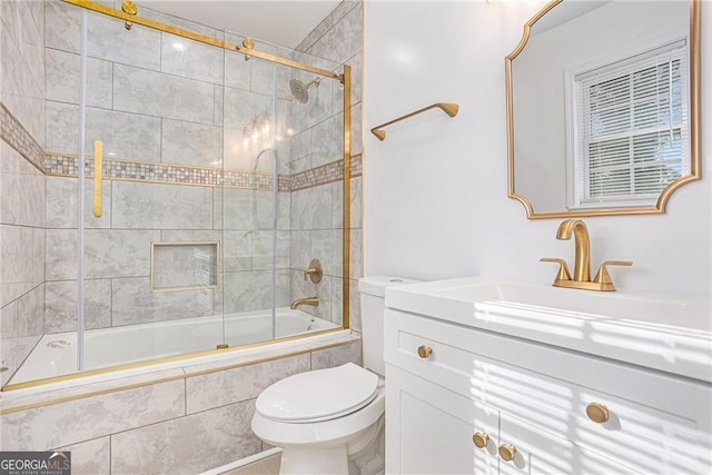 bathroom featuring vanity, toilet, and tiled shower / bath