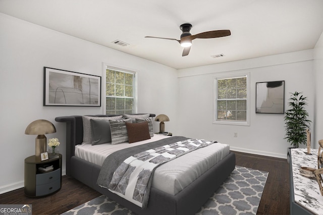 bedroom with visible vents, baseboards, wood finished floors, and a ceiling fan