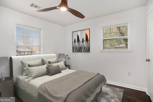 bedroom featuring visible vents, multiple windows, baseboards, and dark wood-style flooring