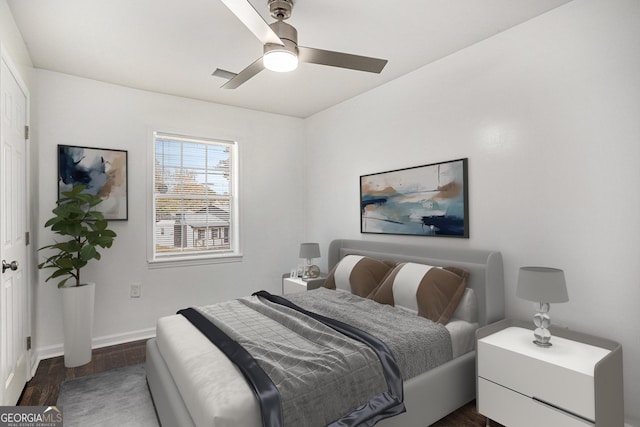 bedroom featuring dark wood finished floors, a ceiling fan, and baseboards