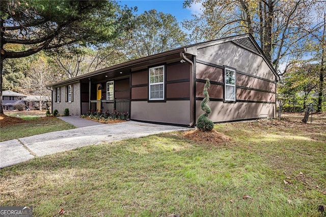 view of front of home featuring concrete driveway, a front lawn, and fence