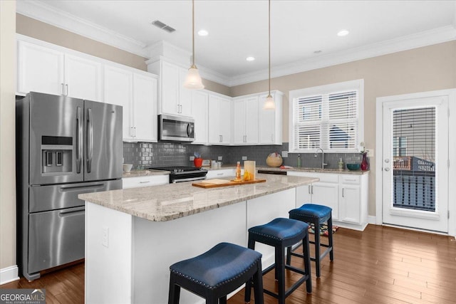 kitchen with visible vents, dark wood-type flooring, white cabinetry, appliances with stainless steel finishes, and decorative backsplash