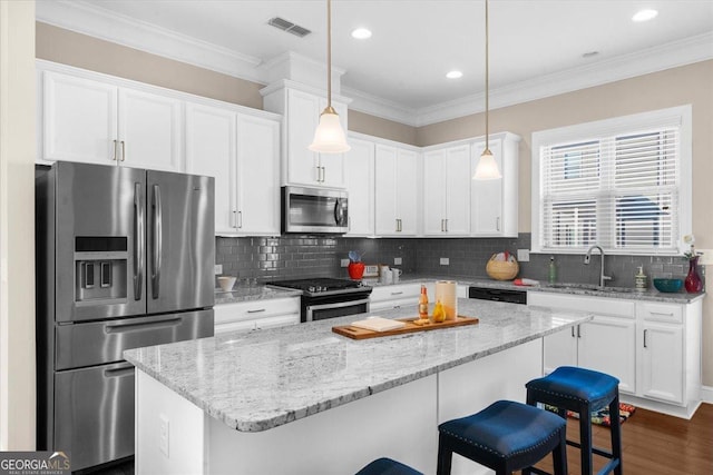 kitchen featuring white cabinets, visible vents, appliances with stainless steel finishes, and a sink