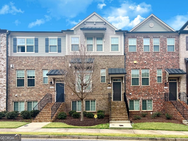 townhome / multi-family property with brick siding and a standing seam roof