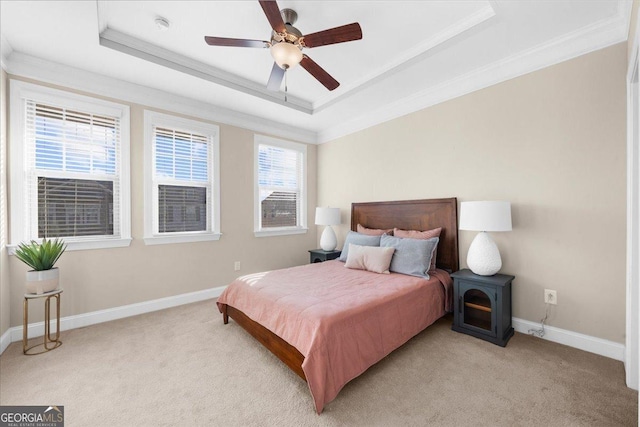 bedroom with a raised ceiling, baseboards, and light carpet