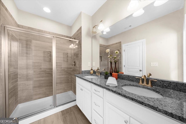 bathroom featuring a sink, visible vents, double vanity, and a shower stall