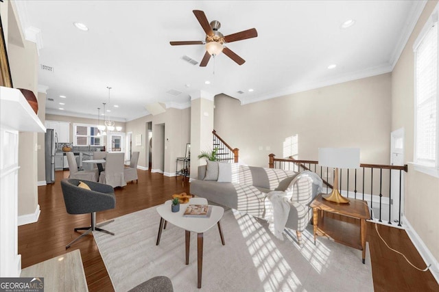 living room with visible vents, a healthy amount of sunlight, ornamental molding, and wood finished floors