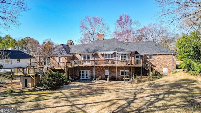 rear view of property featuring french doors, brick siding, a deck, and stairs