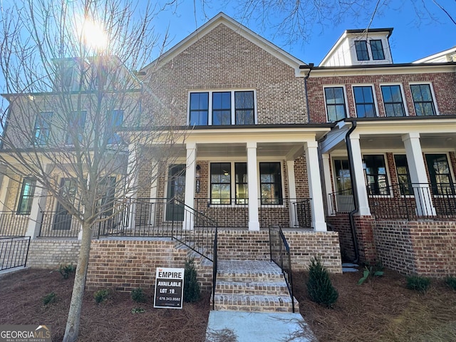 view of front of house with a porch and brick siding