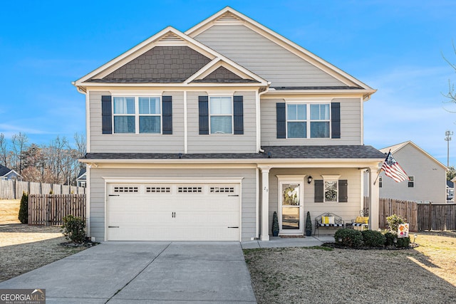 view of front of home with fence, driveway, and an attached garage