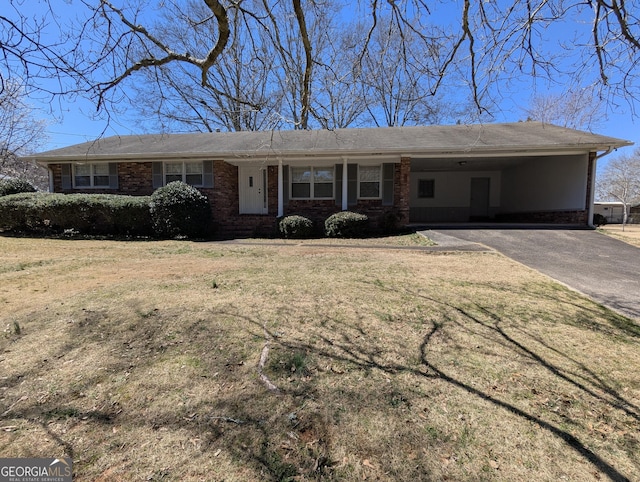 ranch-style home featuring driveway, a front lawn, an attached carport, and brick siding