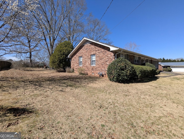 view of side of property with crawl space and brick siding