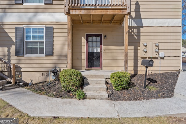 entrance to property with crawl space and a balcony