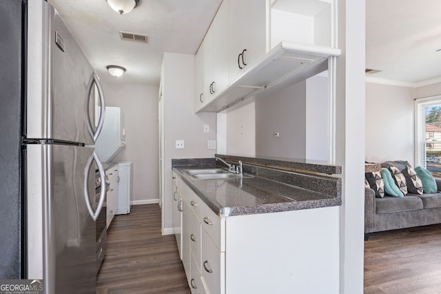 kitchen featuring dark wood-style floors, freestanding refrigerator, visible vents, and a sink