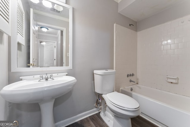 full bath featuring toilet, shower / bath combination, wood finished floors, baseboards, and crown molding