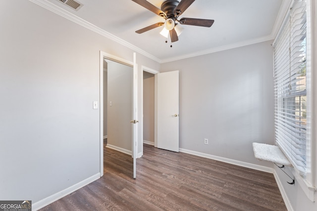 unfurnished bedroom featuring wood finished floors, a ceiling fan, visible vents, baseboards, and ornamental molding