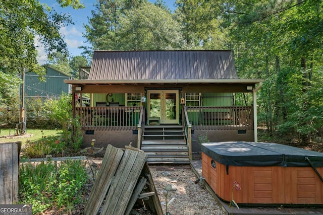 view of front of property with a hot tub, metal roof, and french doors