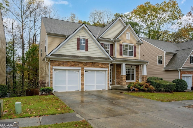 craftsman inspired home with stone siding, a front yard, and driveway