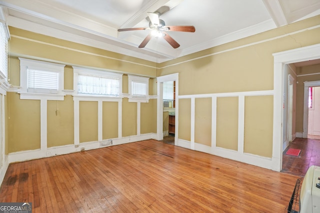 unfurnished room featuring beamed ceiling, hardwood / wood-style floors, a ceiling fan, and ornamental molding