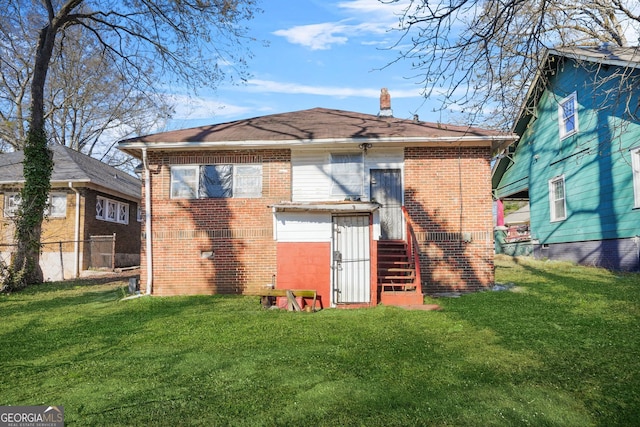 back of house featuring brick siding, a lawn, a chimney, and fence