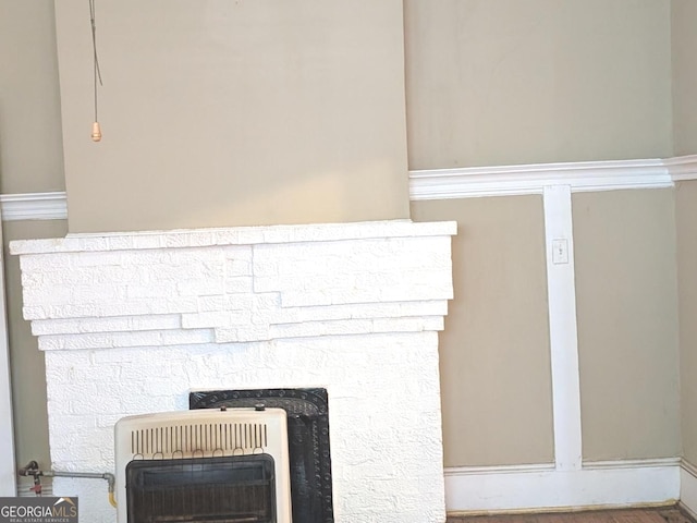 room details featuring a stone fireplace and heating unit