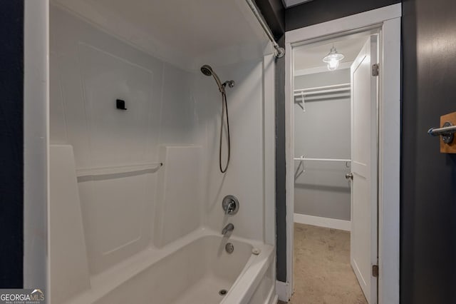 full bathroom with a walk in closet, bathing tub / shower combination, and baseboards