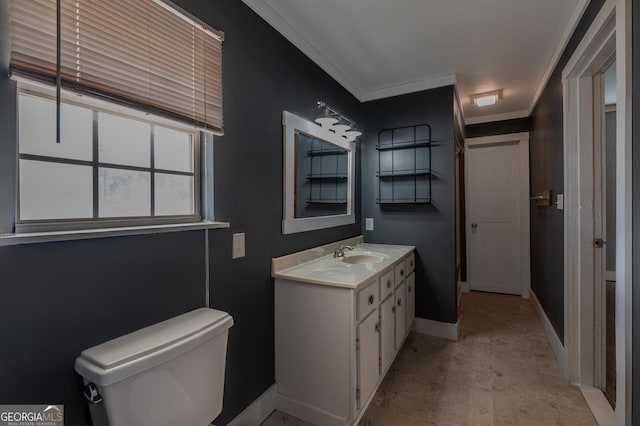 bathroom featuring crown molding, vanity, toilet, and baseboards