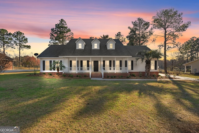 view of front of home featuring covered porch and a yard