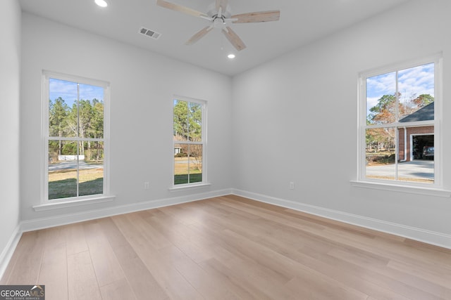 empty room featuring light wood-type flooring, baseboards, visible vents, and recessed lighting