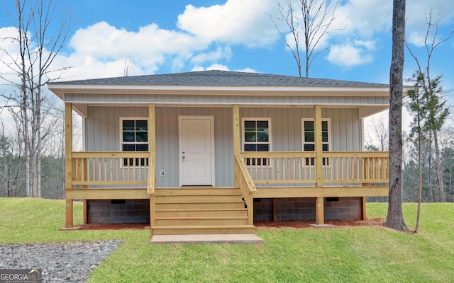 view of front of property featuring a porch, a front lawn, and a shingled roof