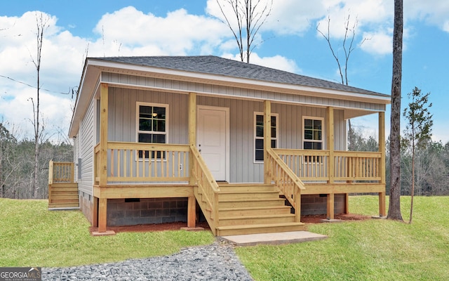 view of front of property featuring a front lawn, a porch, and roof with shingles