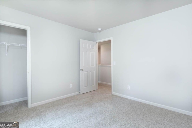 unfurnished bedroom featuring carpet, baseboards, and a closet