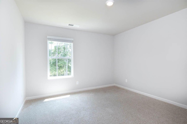 carpeted empty room featuring visible vents and baseboards