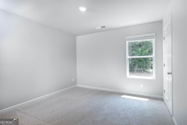 unfurnished room featuring carpet flooring, visible vents, and baseboards