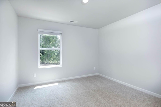 carpeted spare room featuring visible vents and baseboards