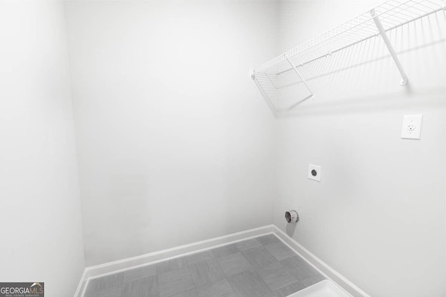 laundry room with laundry area, baseboards, hookup for an electric dryer, and tile patterned floors