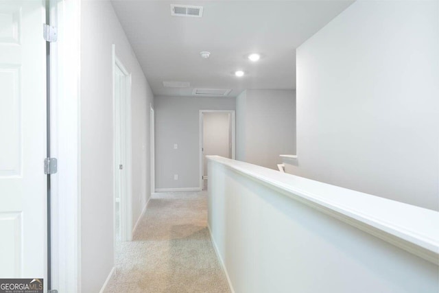 corridor featuring recessed lighting, light carpet, visible vents, baseboards, and attic access