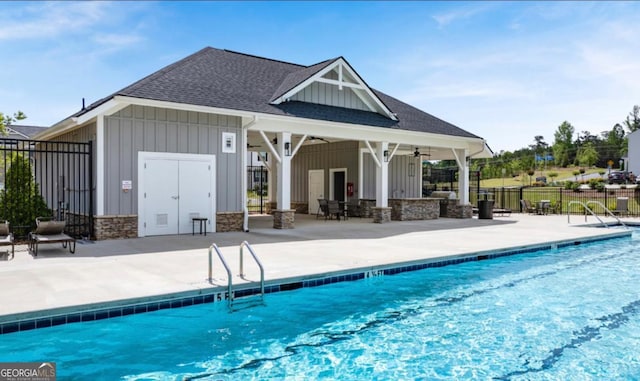 community pool with a patio area, ceiling fan, fence, and an outdoor structure