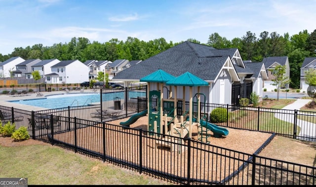 communal playground featuring a residential view, fence, and a community pool