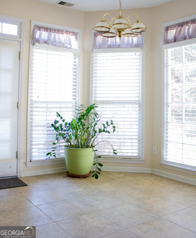 interior space featuring a wealth of natural light, a notable chandelier, and tile patterned floors